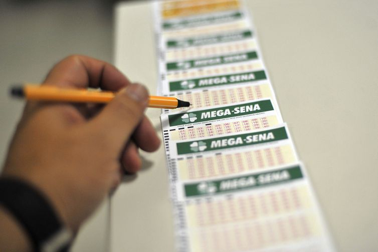 Bilhete de loteria da Caixa Econômica Federal sobre balcão de atendimento.