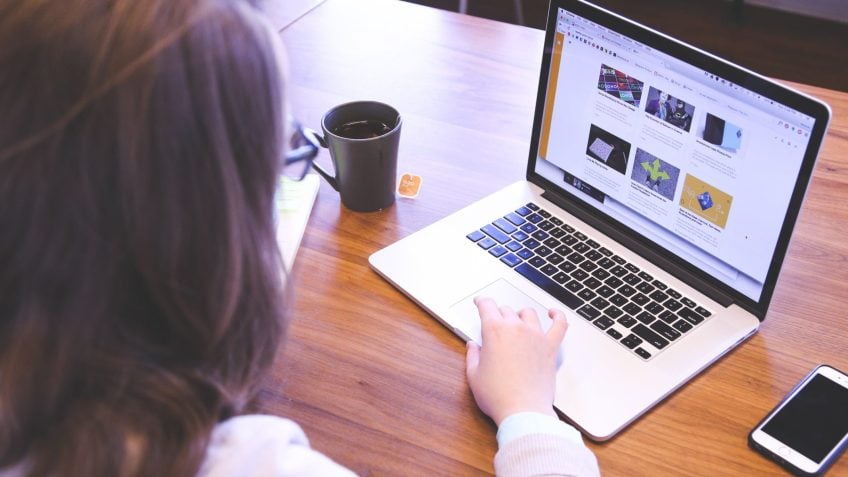 Mulher navega na internet em um computador